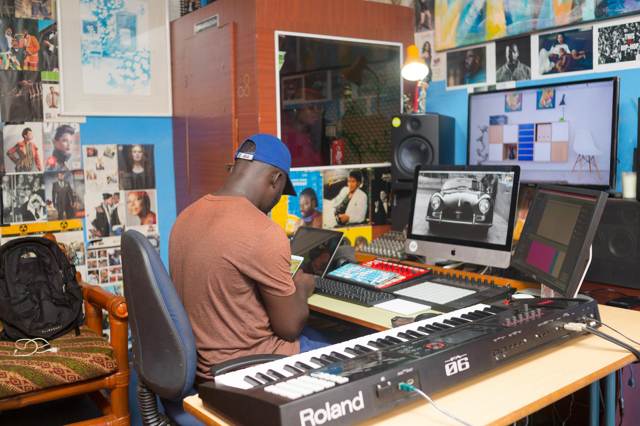 A man working at a modern music production studio with advanced equipment and colorful decor.