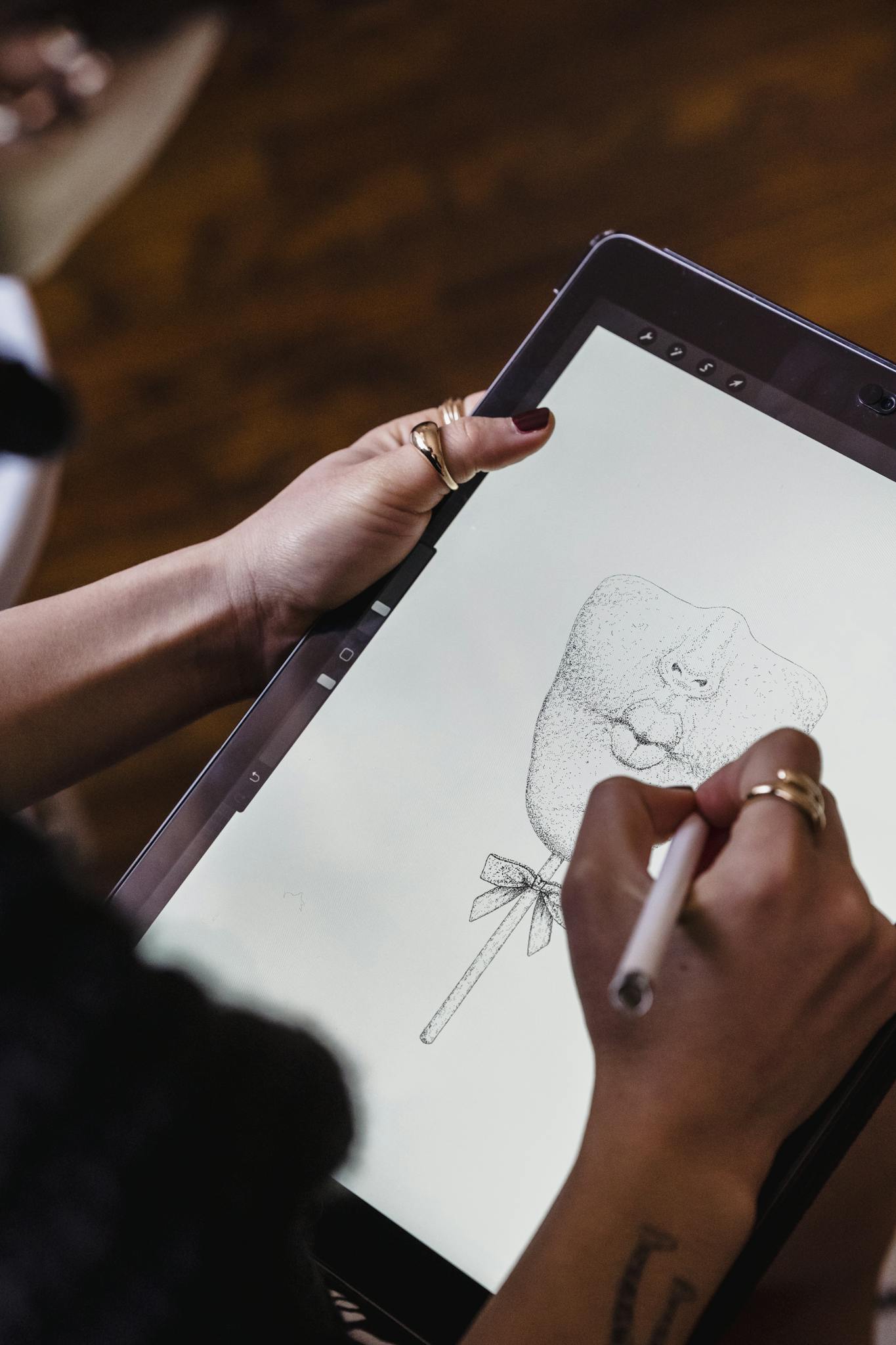 From above of crop anonymous female designer drawing sketch on graphic tablet while working in studio